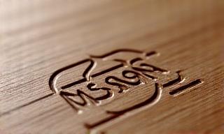 Graveret Kosmos Design logo i træ